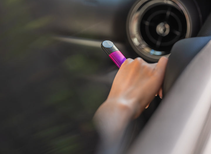 Seseorang sedang memegang RELX di tangan kanannya dalam mobil