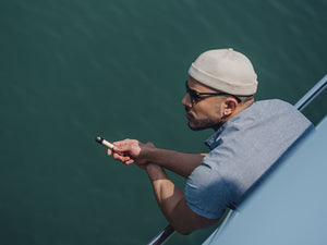 Seorang pria sedang bersandar di perahu sambil memegang RELX Inifity di tangan kanannya 