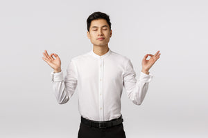 Seorang pria berbaju putih memasang postur meditasi